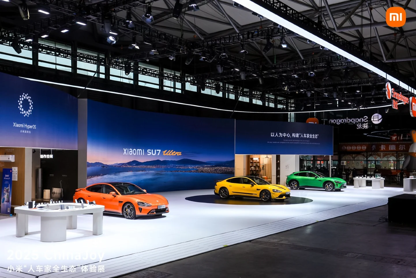 Xiaomi exhibition booth with vehicles and a large blue display